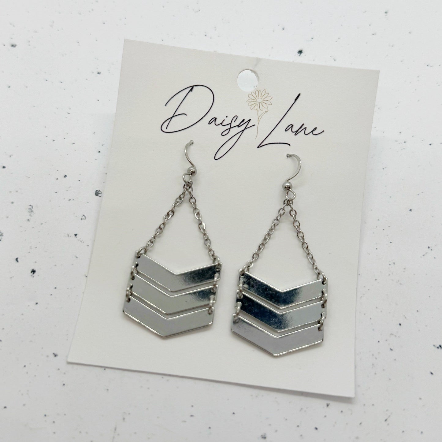 Chevron patterned earrings on a 'Daisy Lane' branded card against a white background